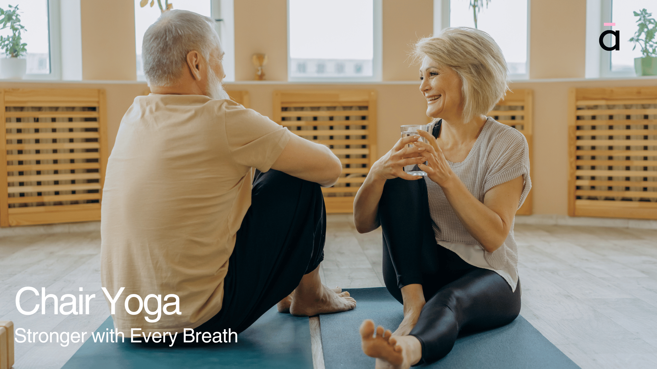 Senior man and woman relaxing post-practice, smiling and seated on yoga mats—challenging common myths about chair yoga for seniors.